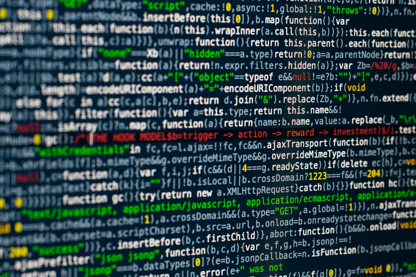Computer programming code scrolling down a dark screen.